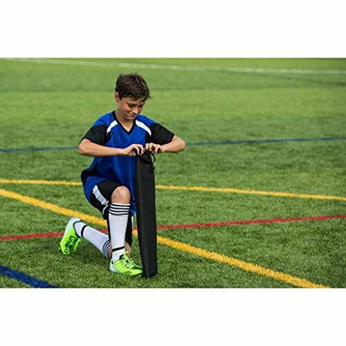 Boy in soccer uniform kneeling on field.