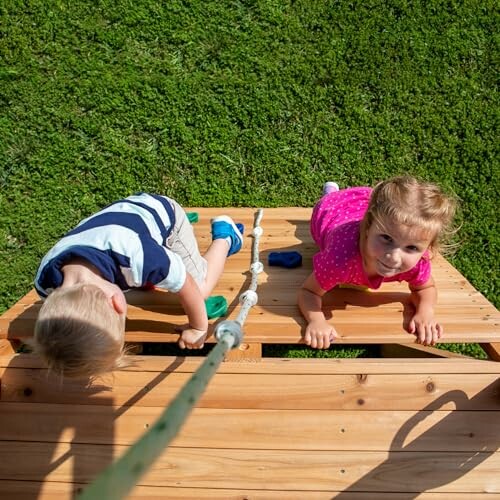 Two children climbing a wooden playground structure
