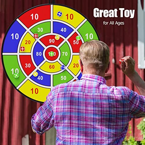 Man playing with colorful dartboard outdoors, demonstrating the versatility of the BooTaa dart board for different settings.