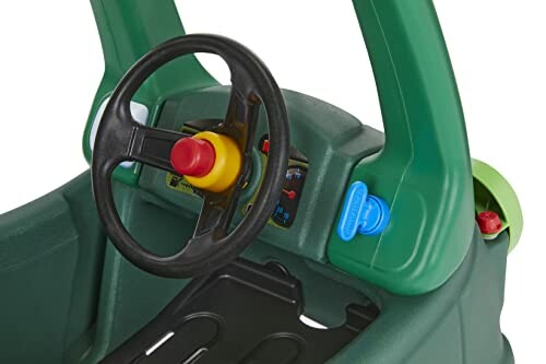 Interior of a green toy car with steering wheel and buttons.