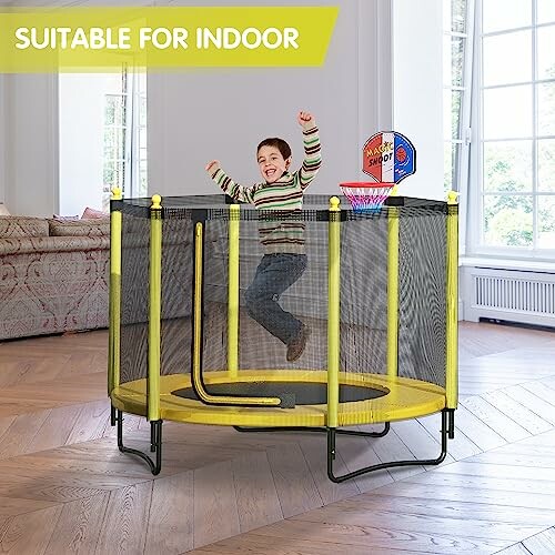 Child jumping on indoor trampoline with safety net and basketball hoop.