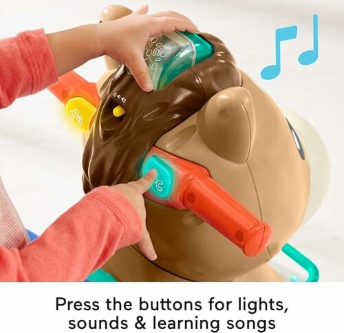 Child pressing buttons on an interactive toy with lights and sounds.