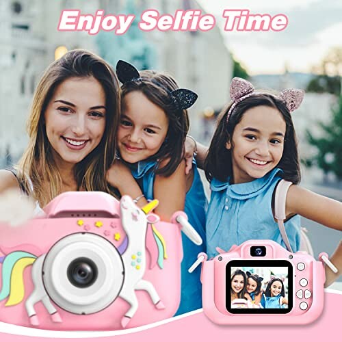 Two smiling children with cat ear headbands taking a selfie with a pink unicorn-themed camera.