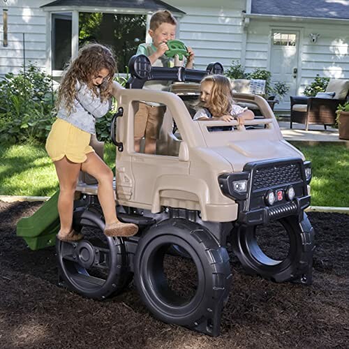 Children playing on a truck-themed playground climber in a backyard.