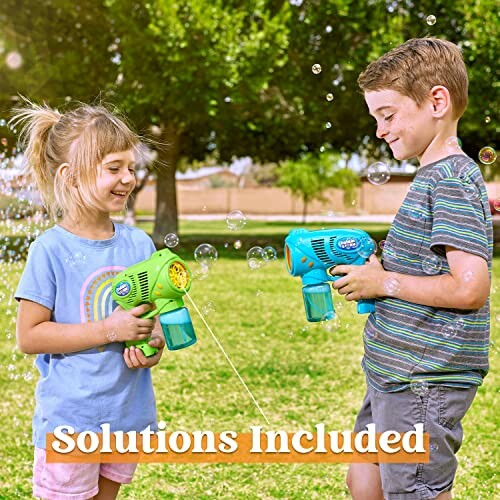 Two children playing with bubble guns in a park.