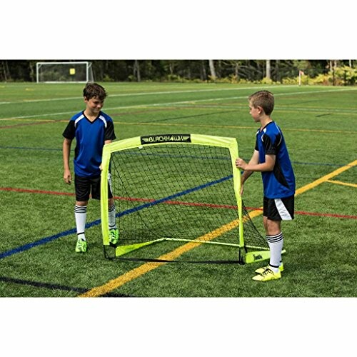 Two kids setting up a small portable soccer goal on a field.