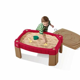 Child playing with sand table and toys.