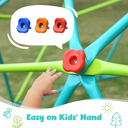 Child's hand reaching for colorful climbing holds on a playground structure.