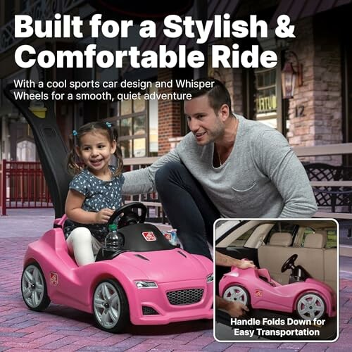Man with child in pink toy car, handle folds for transport.