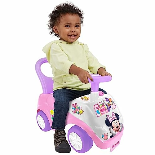 Toddler riding a pink Minnie Mouse ride-on.