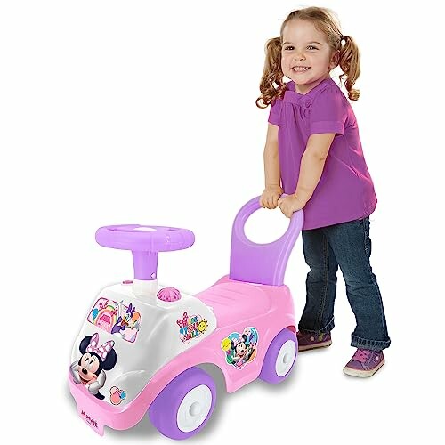Toddler girl with a Minnie Mouse-themed ride-on toy car.