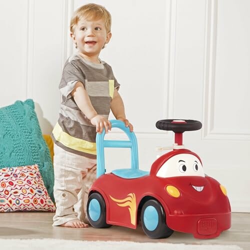 Toddler playing with a red ride-on toy car