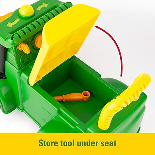 Toy tractor with open storage compartment under seat showing tool.